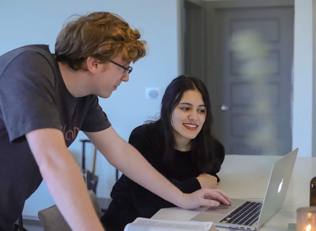 Two colleagues strategize on a laptop, focusing on the 'four sales velocity levers' to boost sales efficiency and drive business growth.